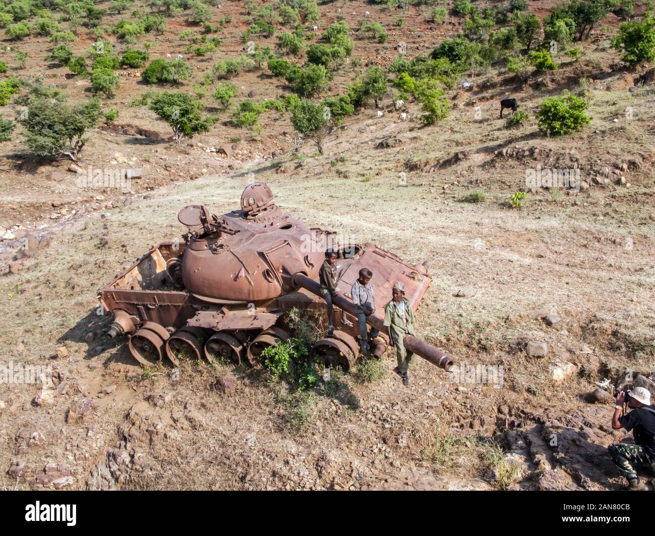 I ragazzi seduti su un vecchio e serbatoio arrugginito dalla strada nel Tigray, Etiopia. Foto Stock