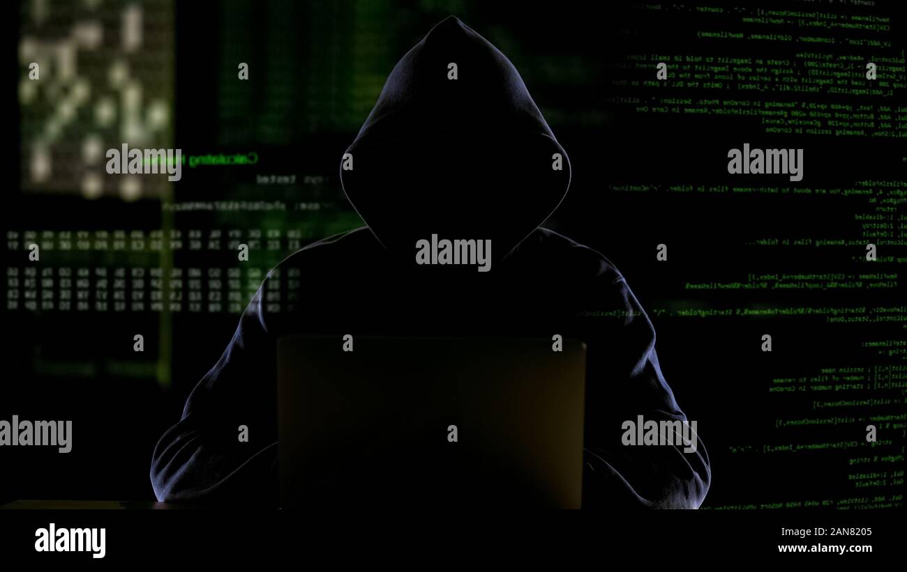 Uomo incappucciato lavora con codice di computer, software di hacking, al furto di dati privati Foto Stock