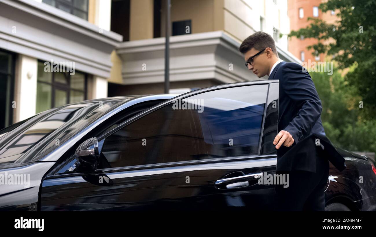 Bello lavoratore di ufficio sempre in nuove auto di lusso vicino al centro business, promozione Foto Stock