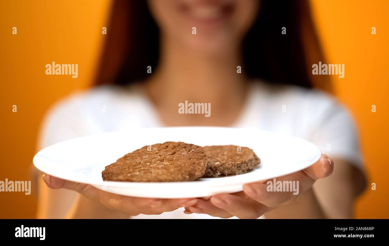 Donna che mantiene cotolette, percentuale di carne di soia in hamburger, fast food quality Foto Stock