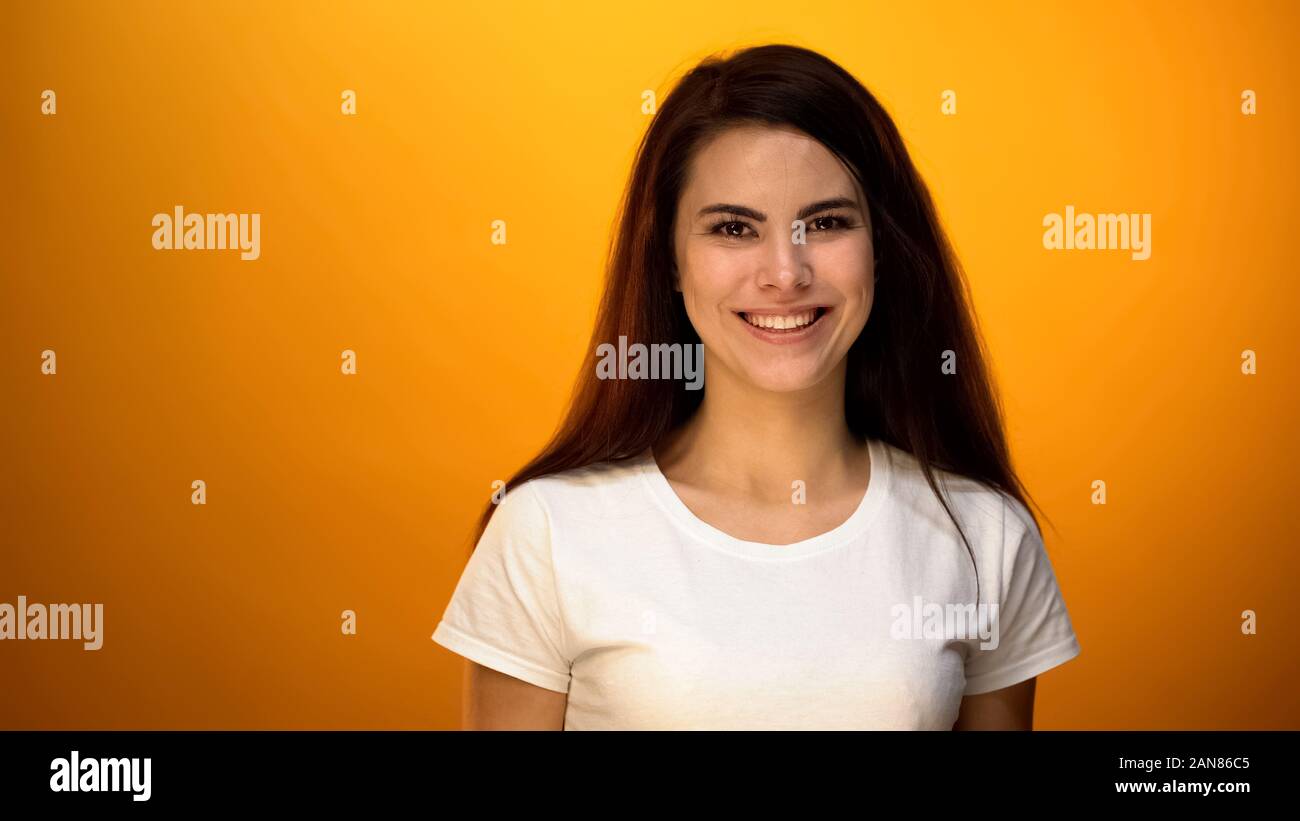 Bella donna sorridente su sfondo giallo, sani e soddisfatti con la vita Foto Stock