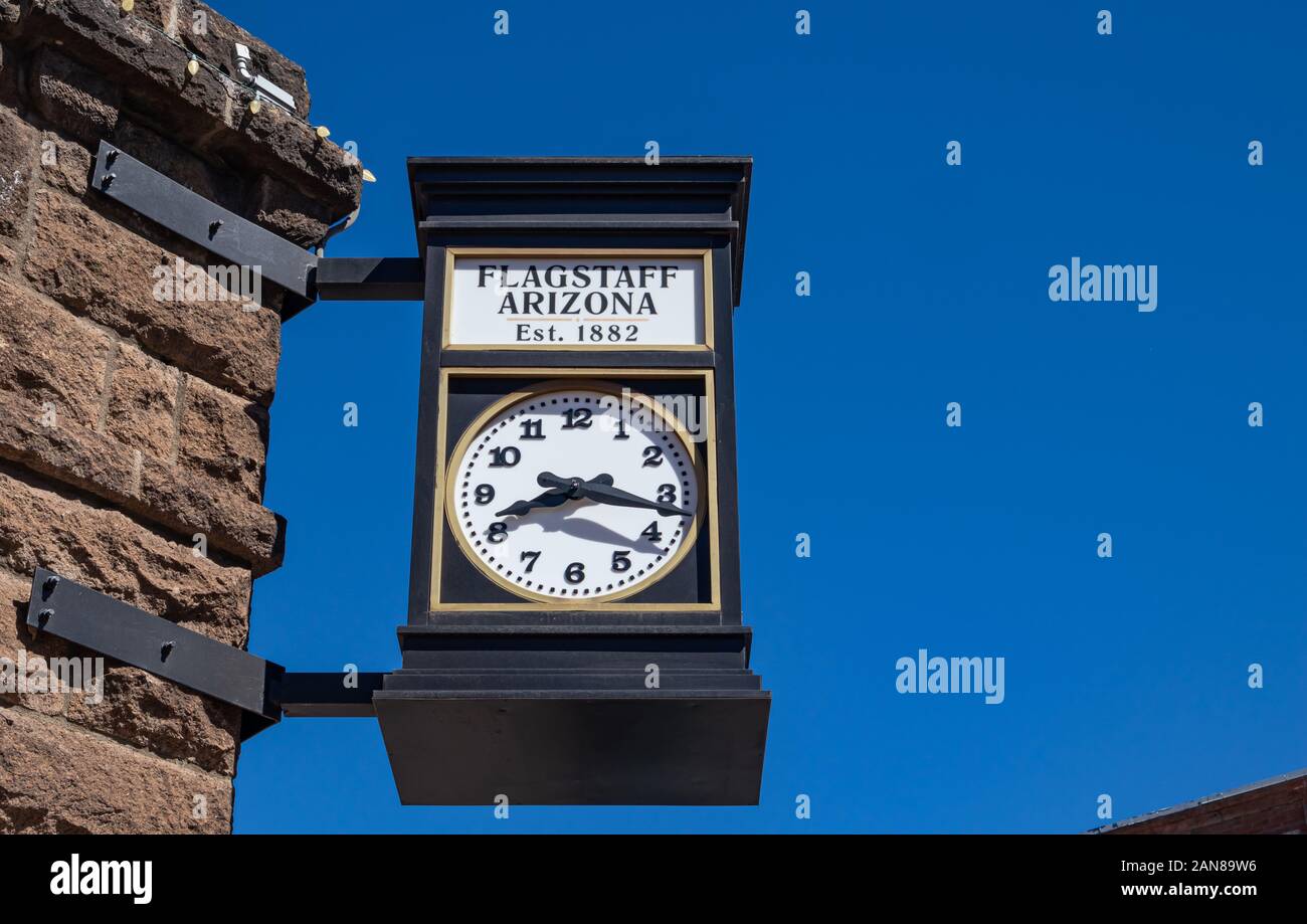 Flagstaff, in Arizona, Stati Uniti d'America. Maggio 25, 2019. Una strada orologio analogico, su un edificio in pietra è il timekeeper per i cittadini. Un vintage, metallo, round watch onu Foto Stock