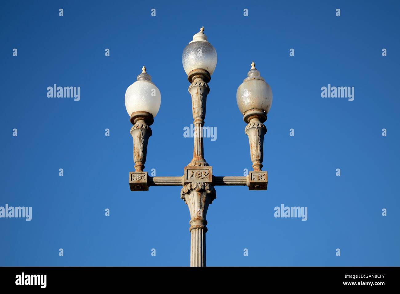 Lampione triplo Globe Vintage decorato contro un cielo azzurro Foto Stock
