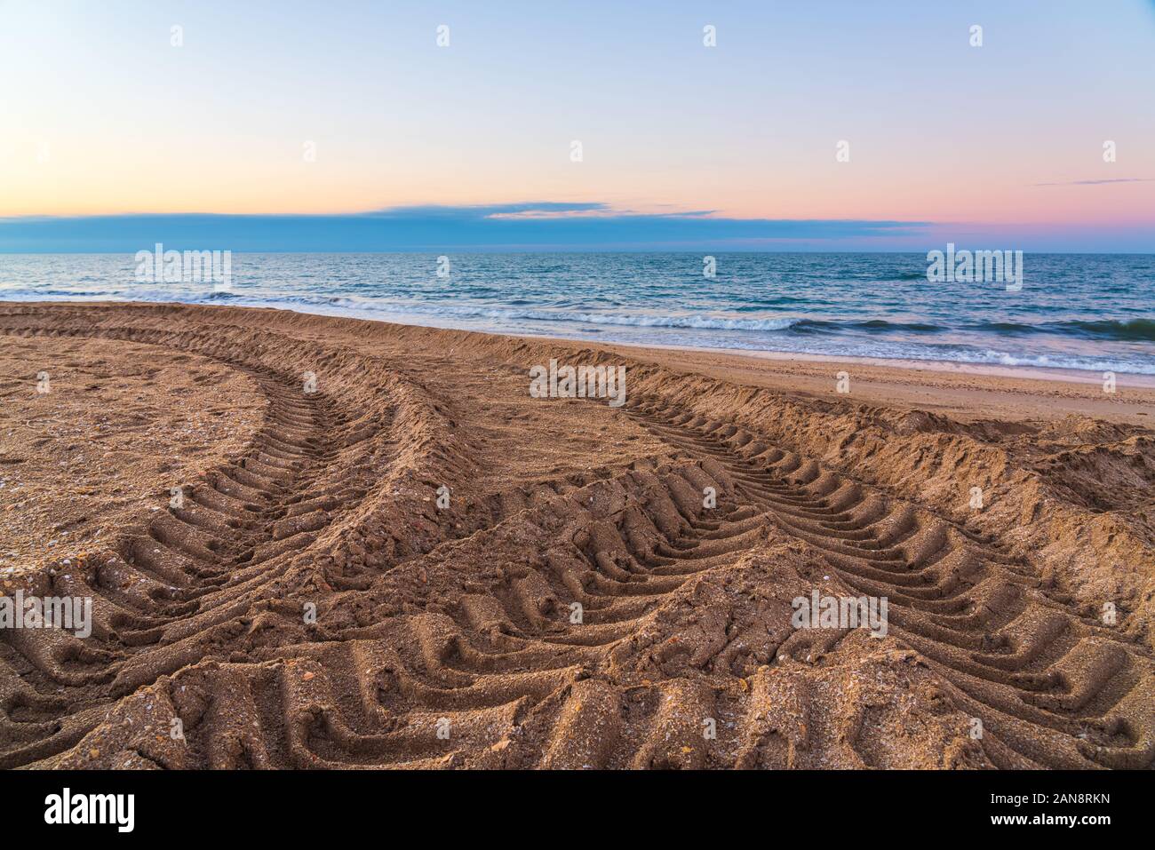 Battistrada del pneumatico segni sulla sabbia di mare Foto Stock