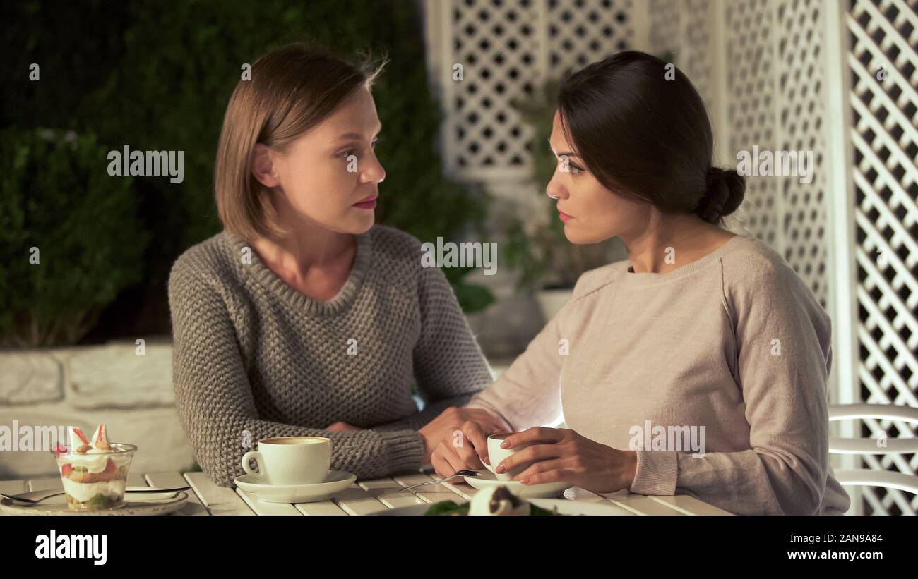 Sorelle parlando di vita, seduti sulla terrazza insieme, problema discussione Foto Stock