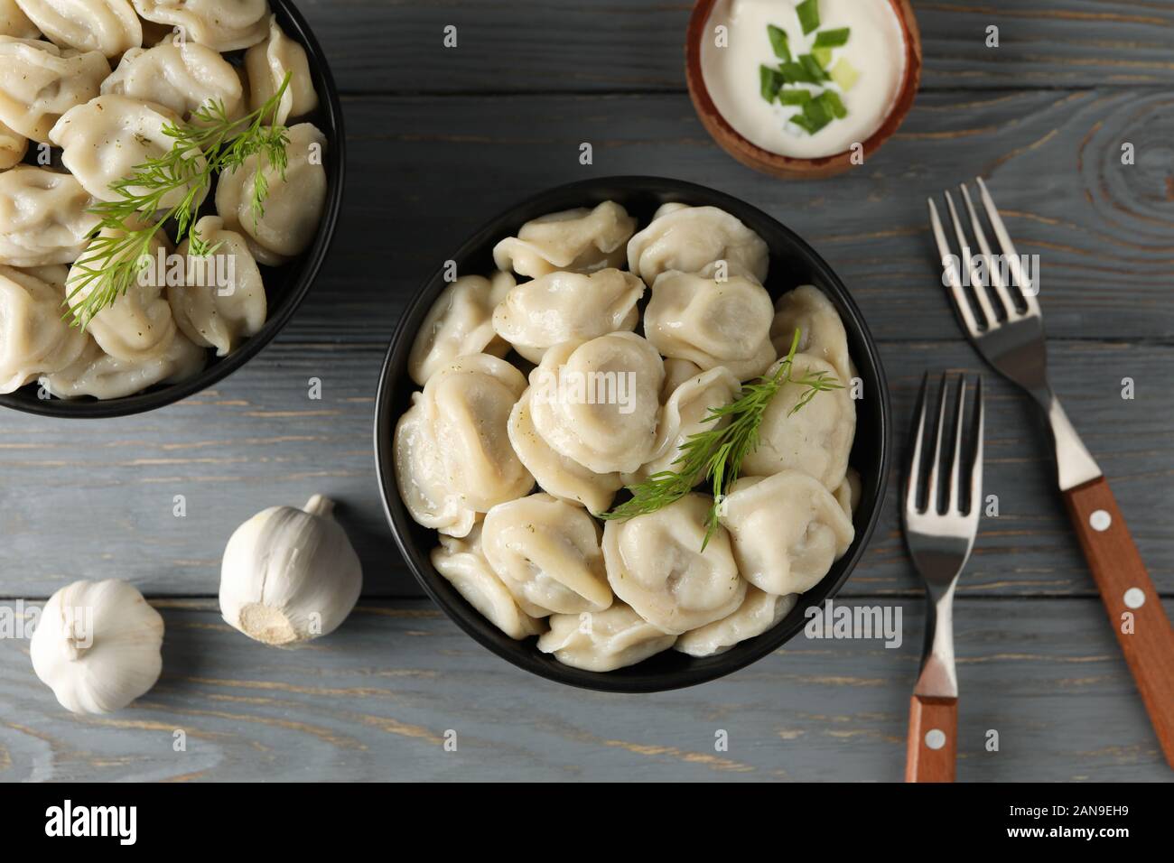 Bocce con gnocchi e forche su sfondo di legno, vista dall'alto Foto Stock