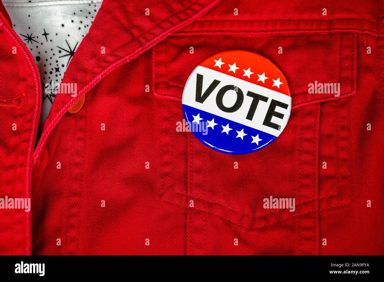 Close up della campagna politica votare il pulsante rosso sulla tasca della giacca Foto Stock