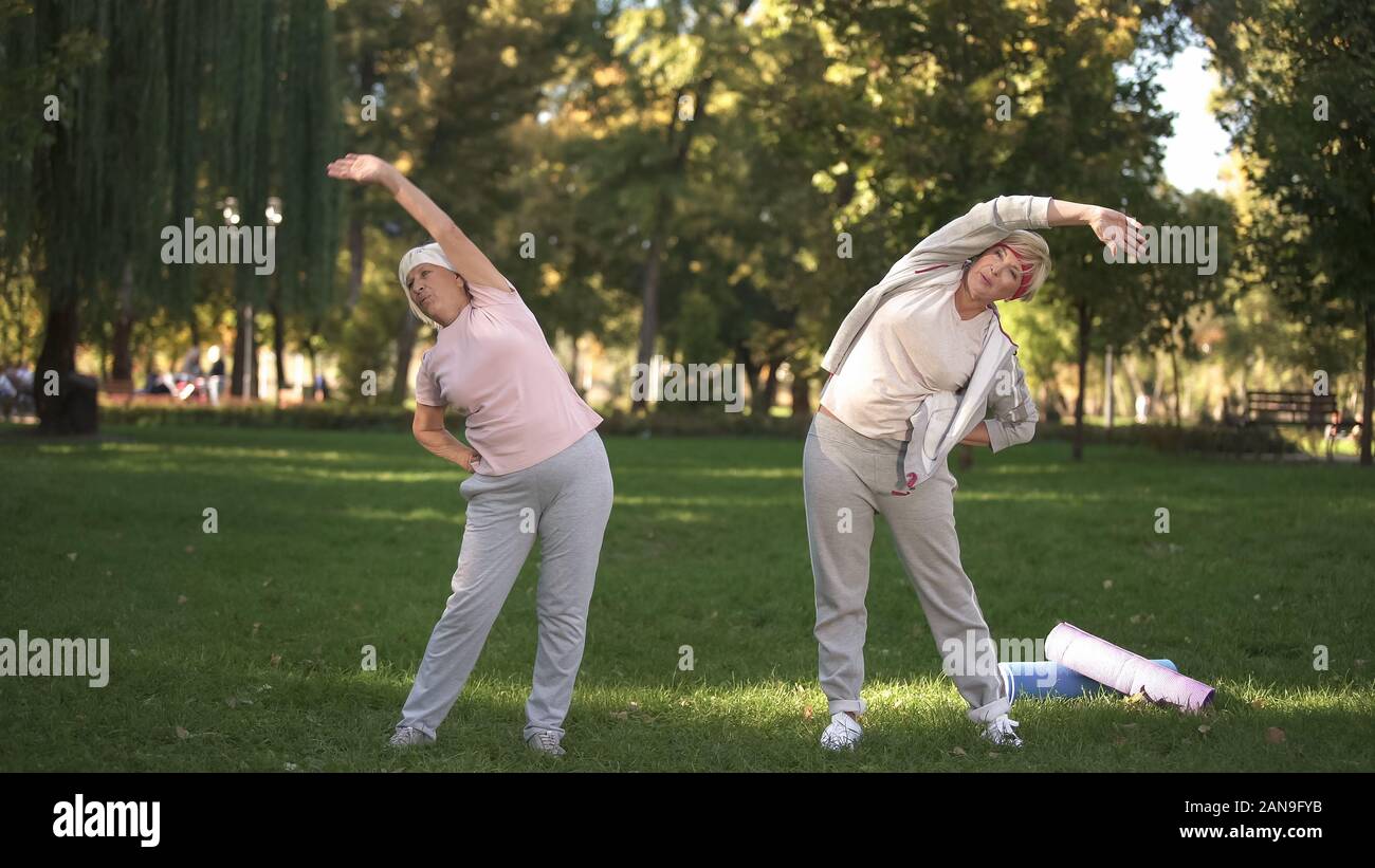 Mamma e figlia facendo allenamento nel parco, uno stile di vita sano in sambuco età Foto Stock