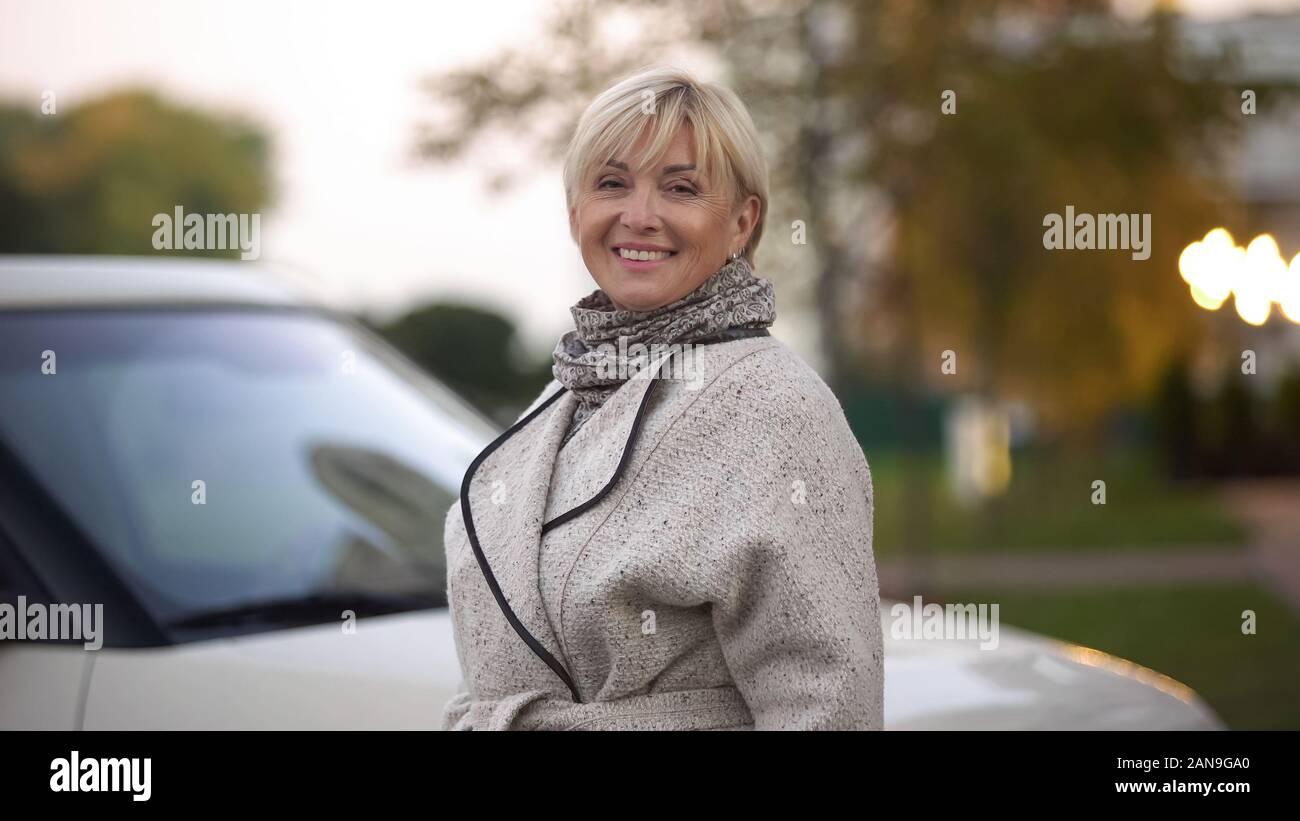 Attraente anziana signora sorridente in posa per la telecamera, puro e una pelle sana, wellness Foto Stock