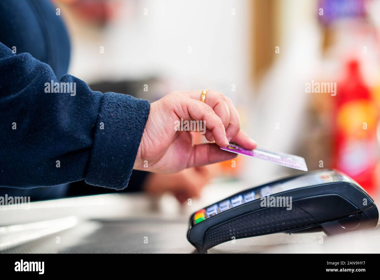 Chiusura del cassiere è utilizzando il credito contactless card terminale pos per ottenere il pagamento Foto Stock