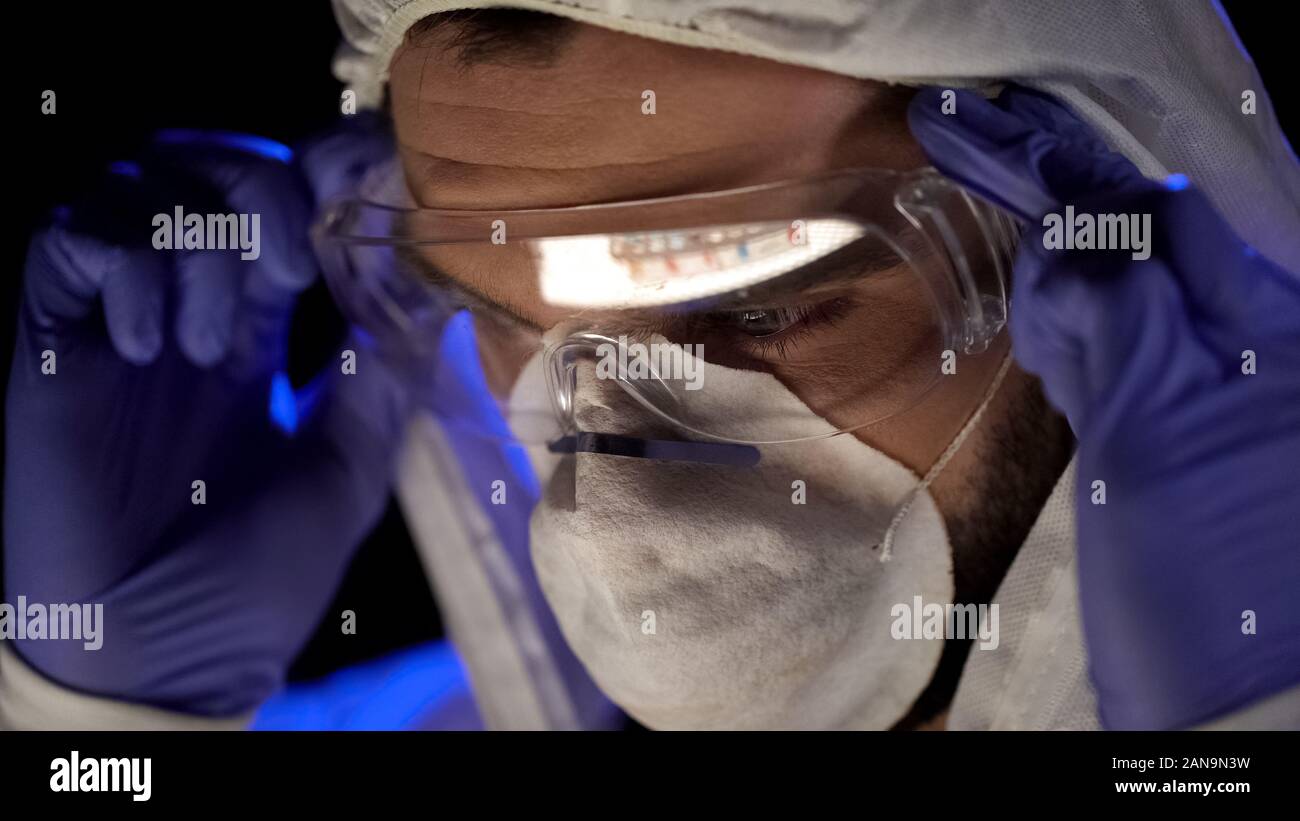 Assistente di laboratorio con gli occhiali, la riflessione di provette con sostanza chimica Foto Stock