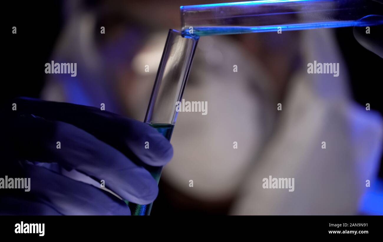 Scienziato combinando elementi in provetta, la fabbricazione di armi biologiche Foto Stock