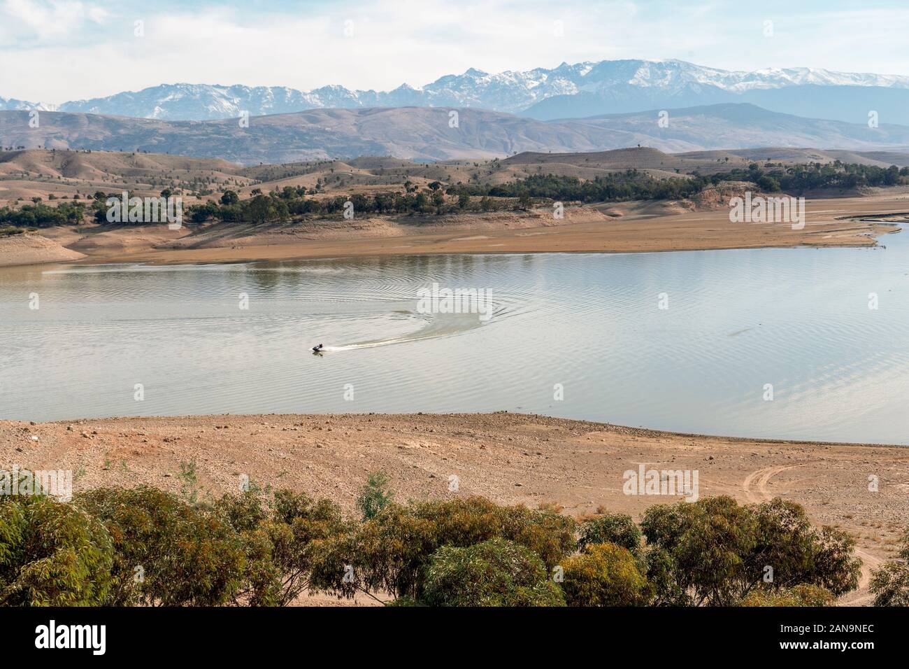 Il motoscafo sul bellissimo lago Takerkoust e montagne a sud di Marrakech, Marocco Foto Stock