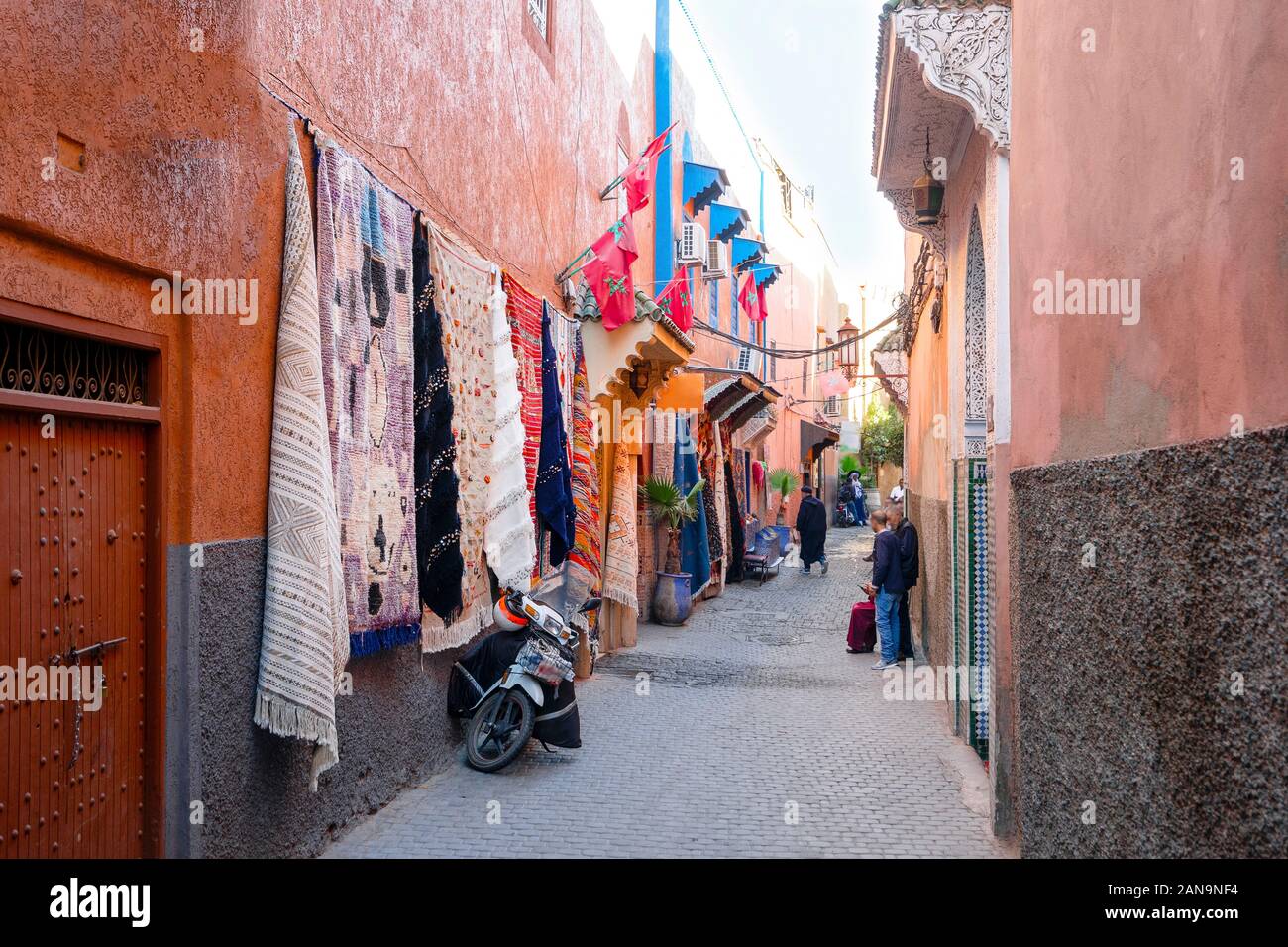 Strada stretta della vecchia medina con negozio di tappeti a Marrakech, Marocco Foto Stock