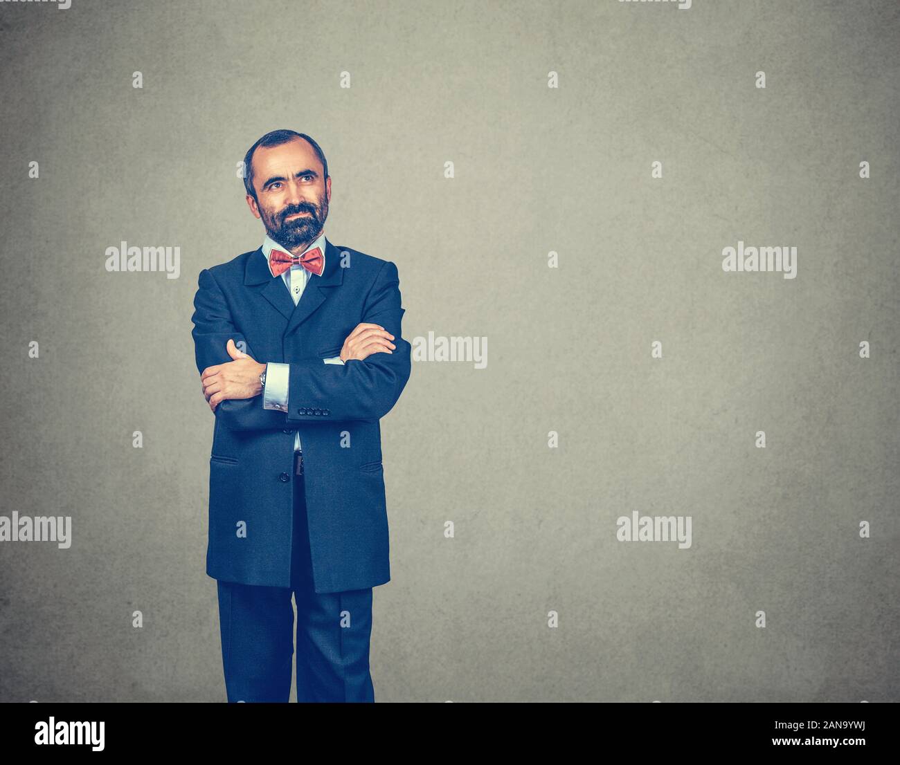 Pensare. Uomo Barbuto in abbigliamento formale alla ricerca fino al lato copia spazio. Espressivo volto positivo. Bracci incrociati. Gara di misto modello barbuto isolato Foto Stock