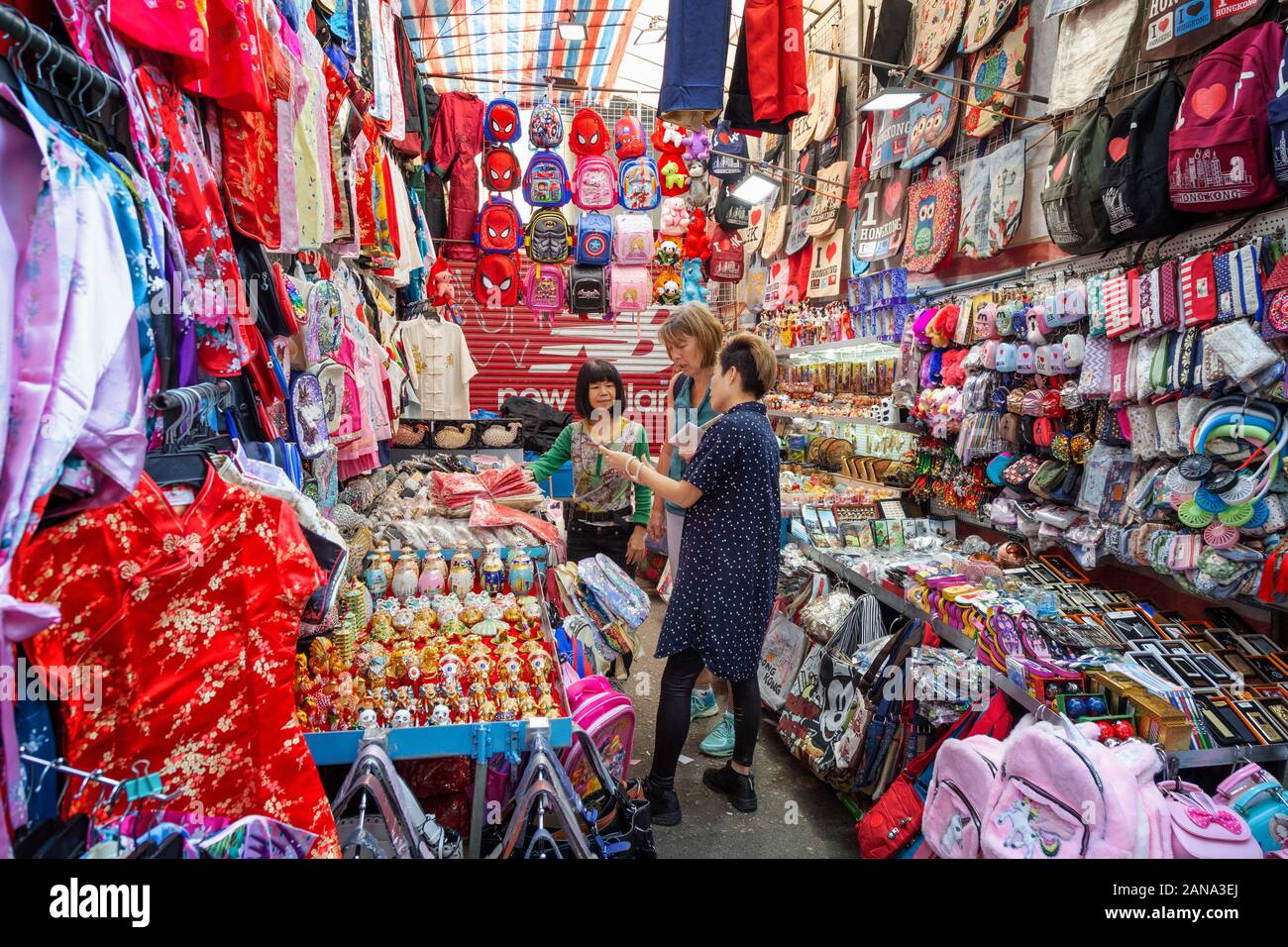 Kowloon Hong Kong mercato; una turista ad acquistare vestiti in un mercato in stallo, Kowloon, Hong Kong Asia Foto Stock