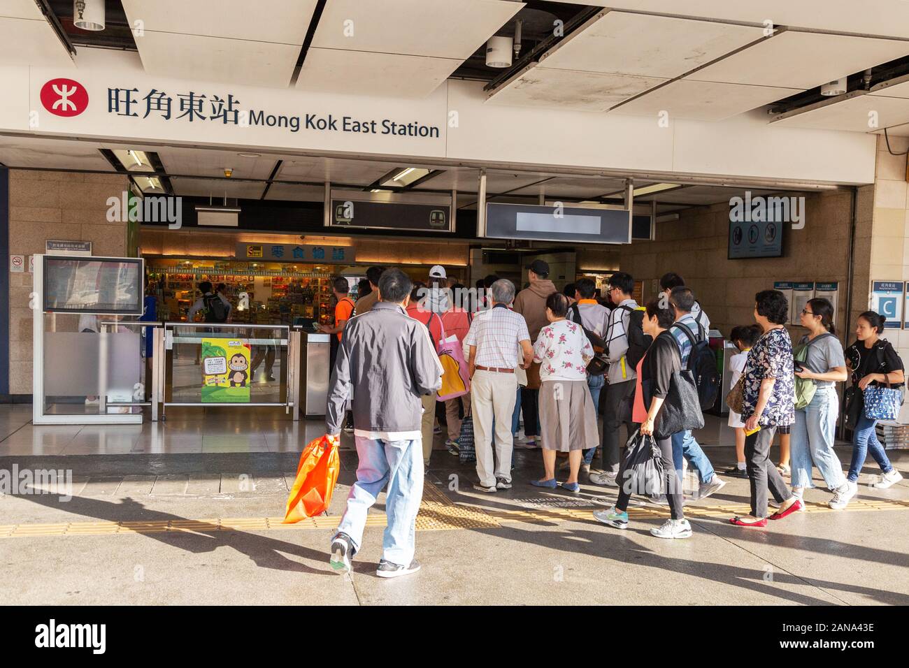 Trasporti pubblici di Hong Kong - persone che entrano nella stazione di Mong Kok East, per viaggiare sulla MTR di Hong Kong (ferrovia di transito di massa); Kowloon Hong Kong Asia Foto Stock