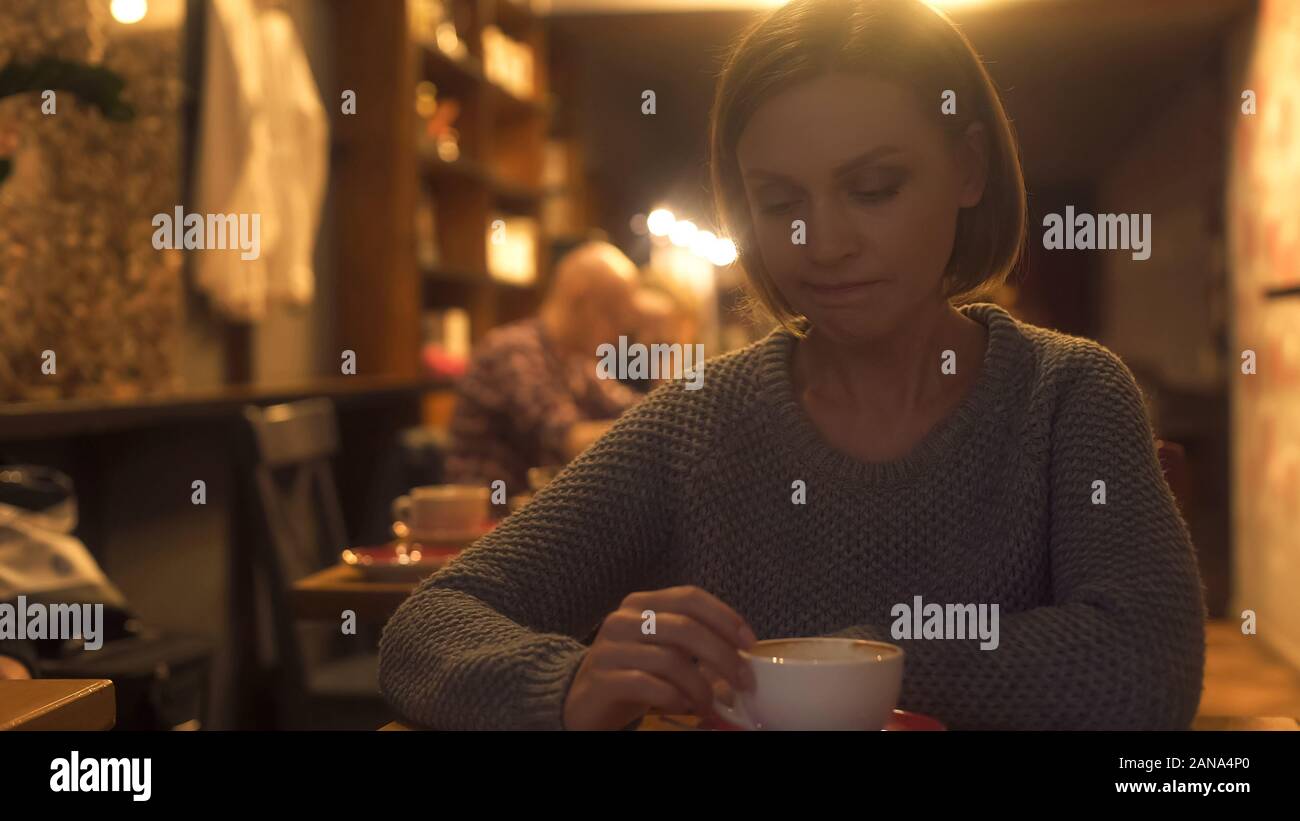 Triste donna seduta al cafe, sperimentando dolorosamente break-up, la solitudine, la crisi Foto Stock