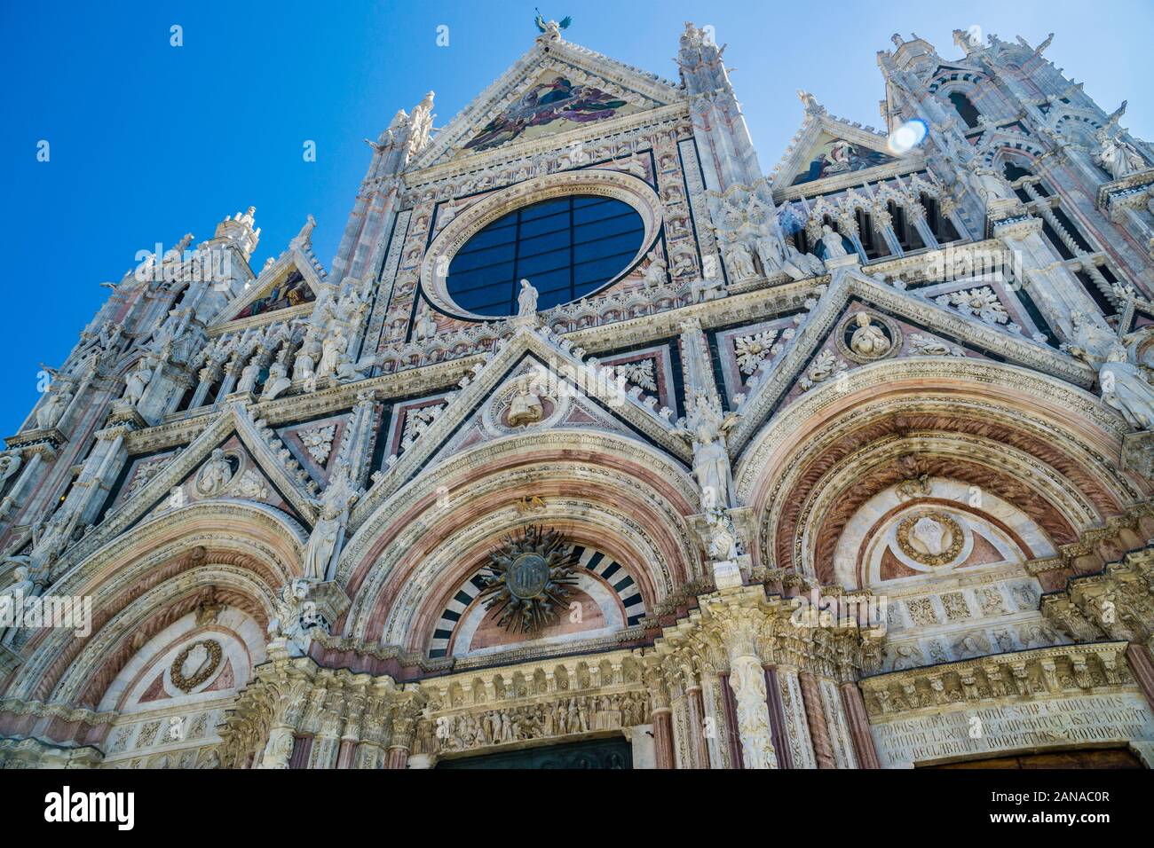 Facciata ovest della cattedrale di Siena con strisce alternate di colore bianco e verde-marmo nero con le sue tre portale, agendo come la principale porta d ingresso al D Foto Stock