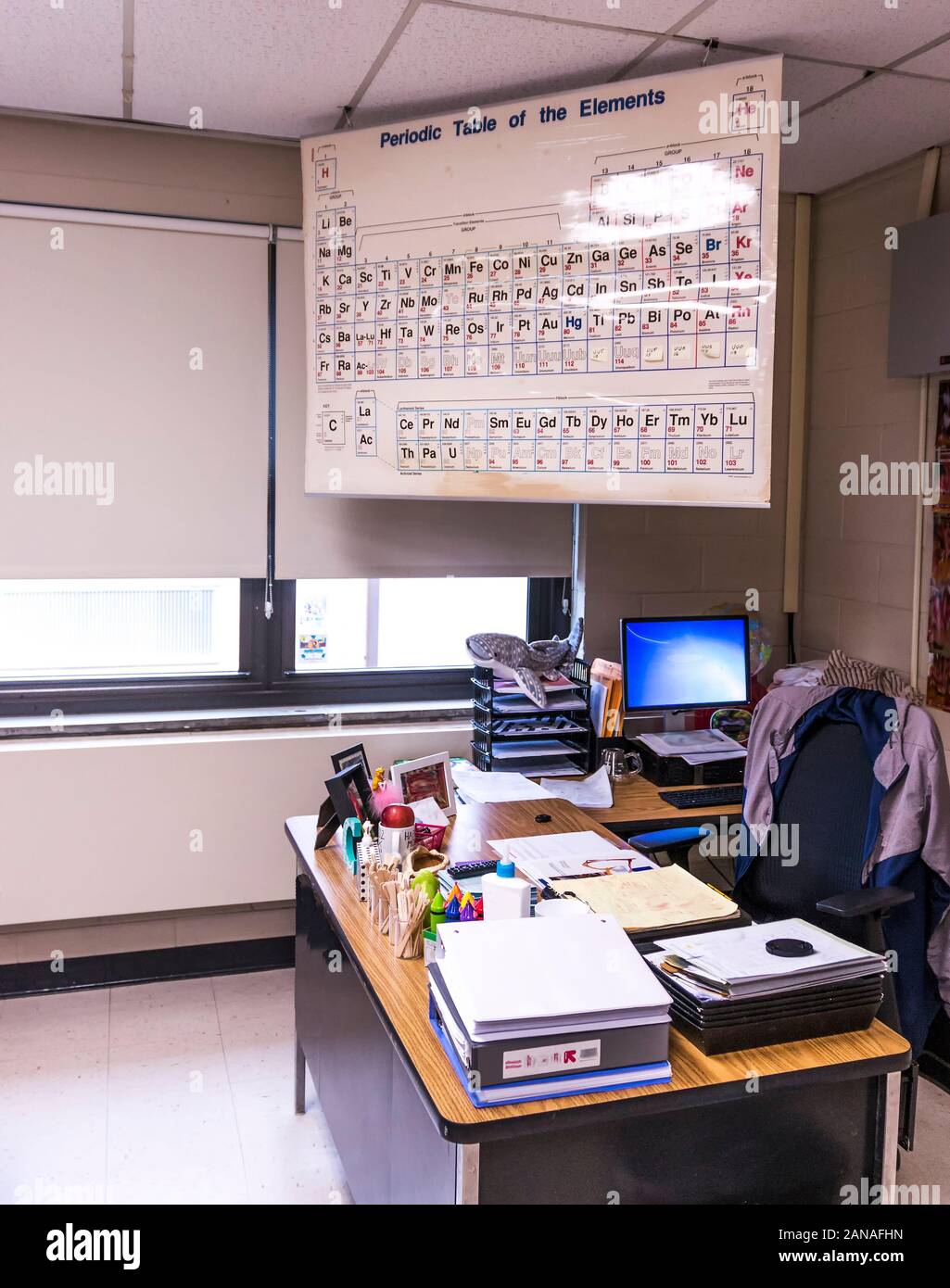 Una scuola di alta classe chimica insegnanti scrivania con tavola periodica al di sopra di esso. Foto Stock