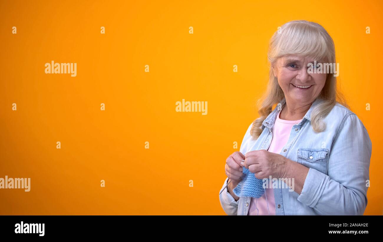 Allegro invecchiamento Maglieria donna e sorridente alla telecamera, tradizioni familiari, hobby Foto Stock