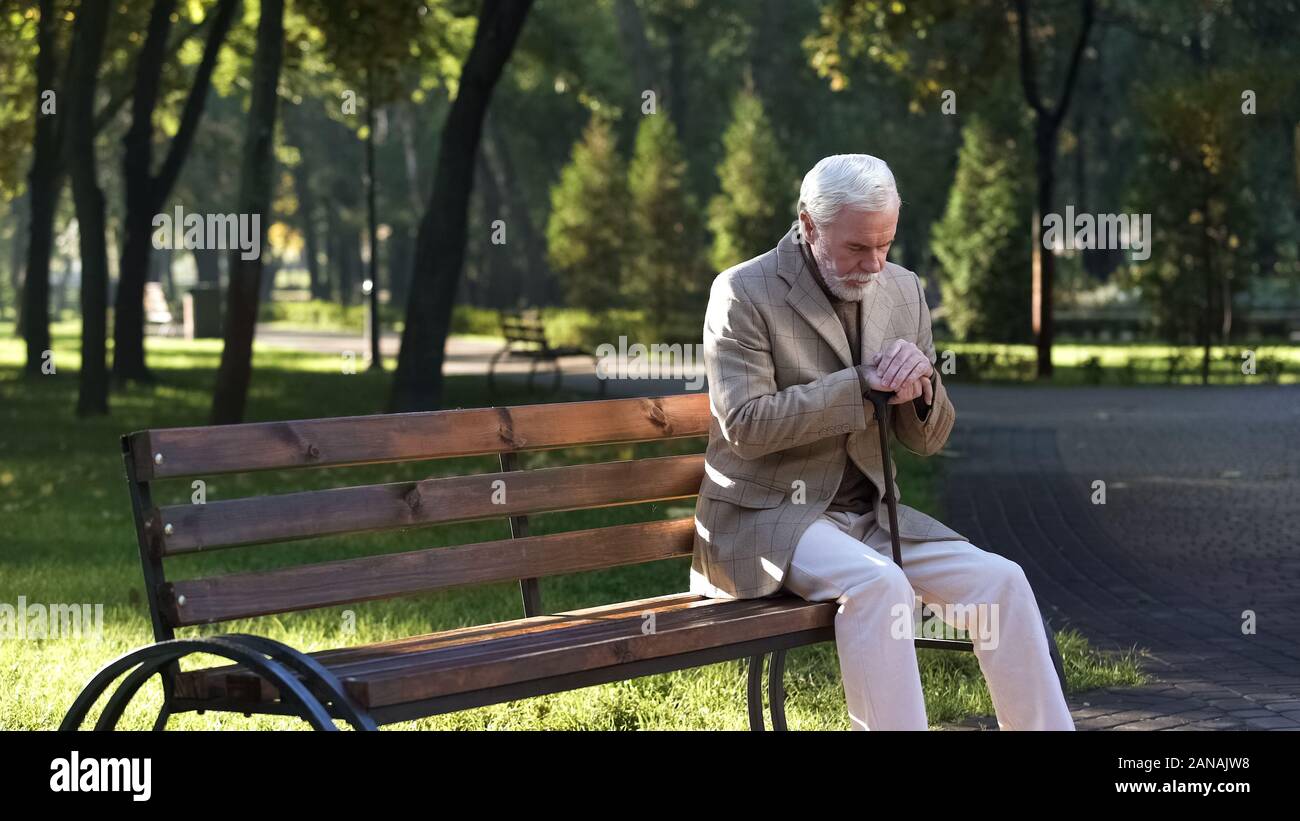 Lonely sconvolto il vecchio uomo seduto da solo nel parco e pensando a vita, titolare di pensione o di rendita Foto Stock