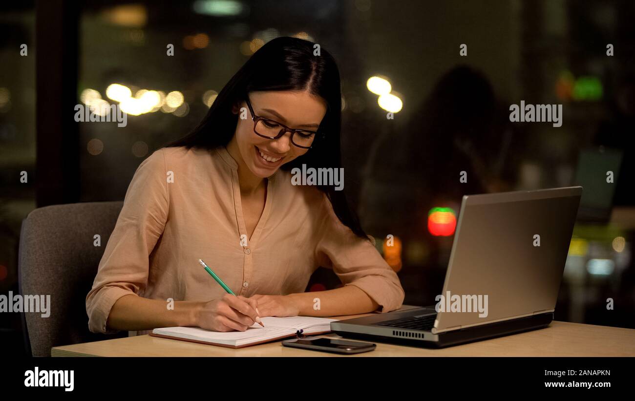 Giovane donna scrivere le idee in notebook, pensando trama del libro, ispirazione Foto Stock