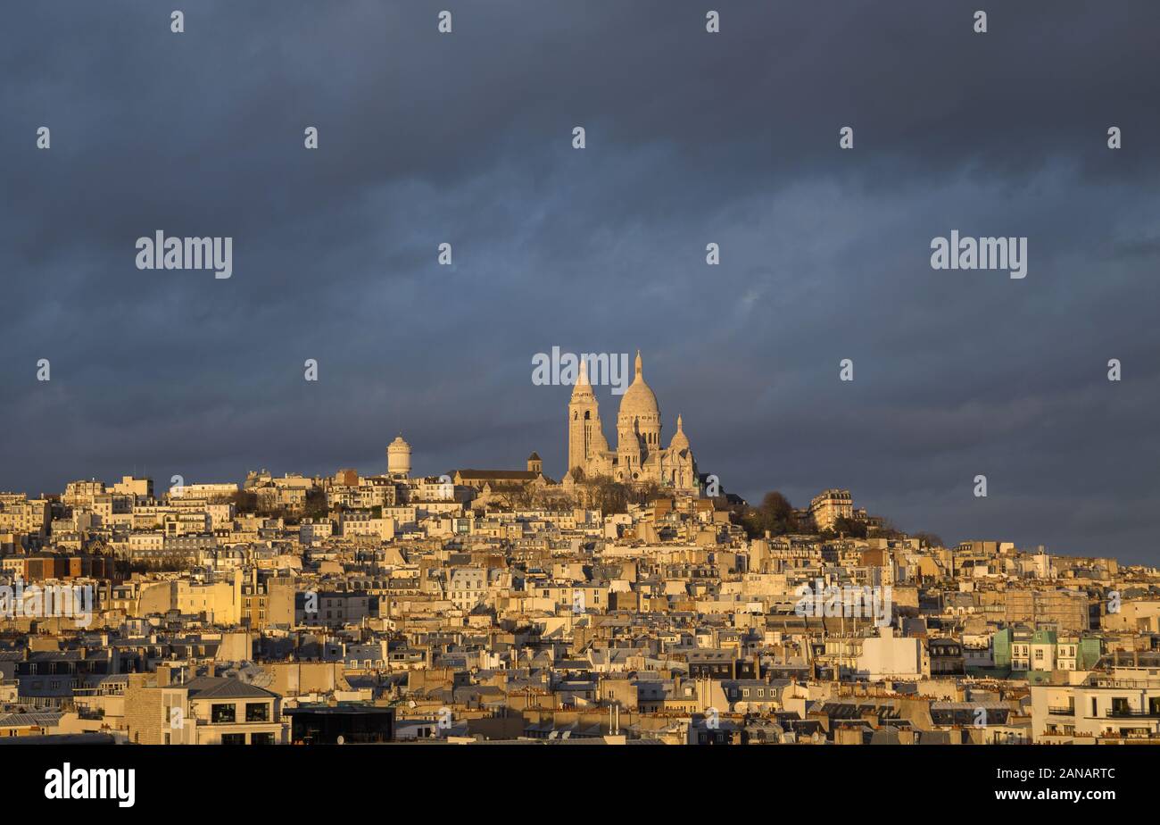 Montmartre e la chiesa del Sacre-Coeur, vista panoramica di Parigi sui tetti con cielo d'inverno drammatico. Francia Foto Stock