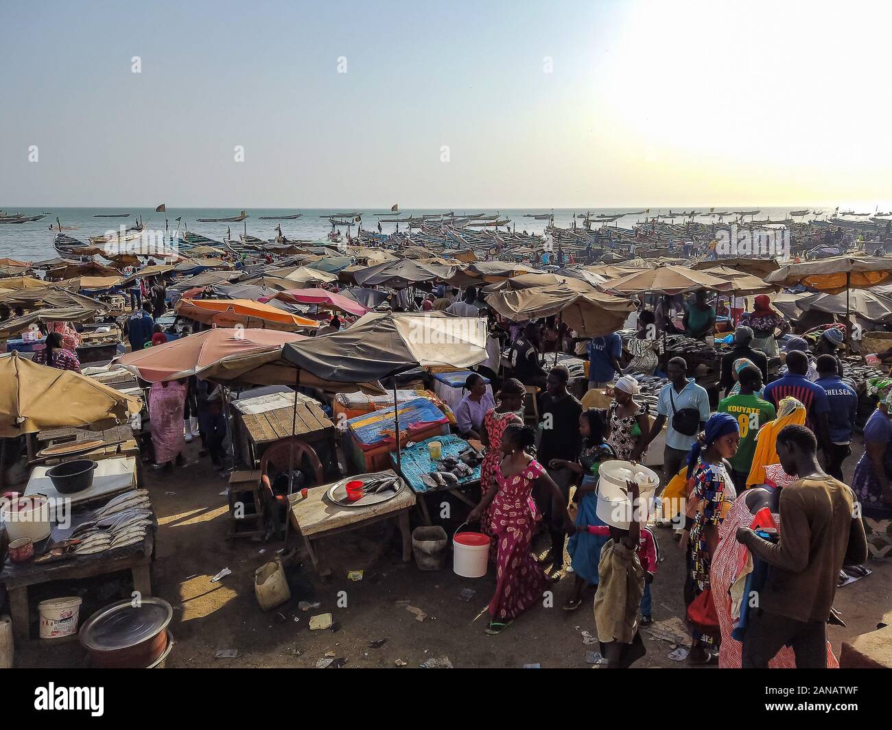 MBour, Senegal- 25 aprile 2019: Senegalesi non identificato di uomini e donne al mercato del pesce del porto della città nei pressi di Dakar. Ci sono bancarelle di vendita e Foto Stock