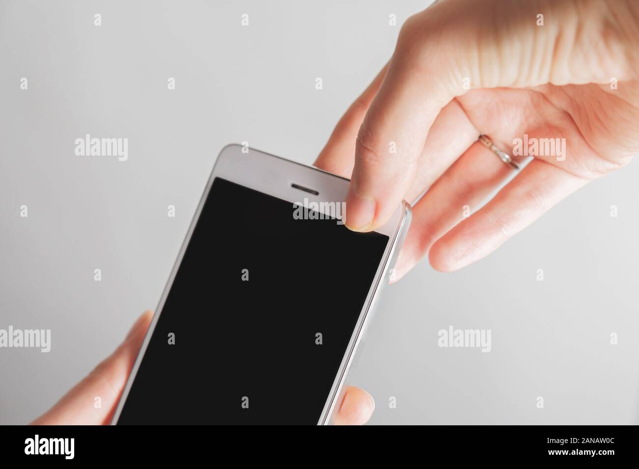 Pollice copre fino alla fotocamera frontale di uno smartphone. Concetto di privacy, sicurezza online di un firewall Foto Stock