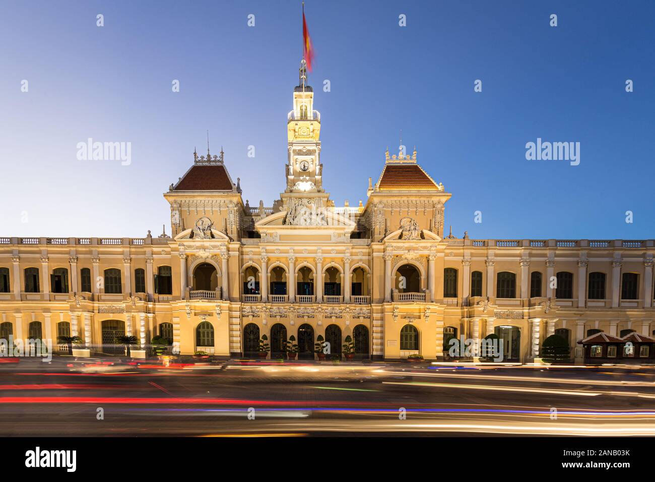 Il traffico correre di notte davanti alla gente famosa presso il comitato dell'edificio nel cuore di Ho Chi Minh city in Vietnam più grande città, aka Saigon. Foto Stock