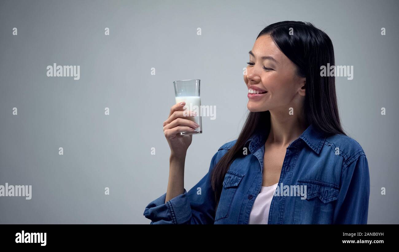 Asian lady tenendo il latte vetro, fonte di calcio e di energia, Bifido prodotto Foto Stock
