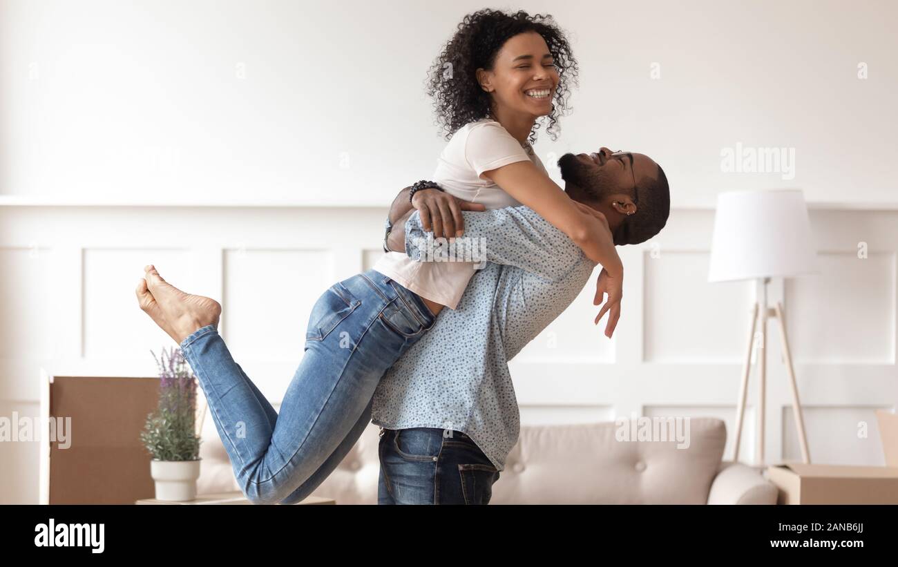 Successo uomo nero sollevando sorridenti moglie. Foto Stock