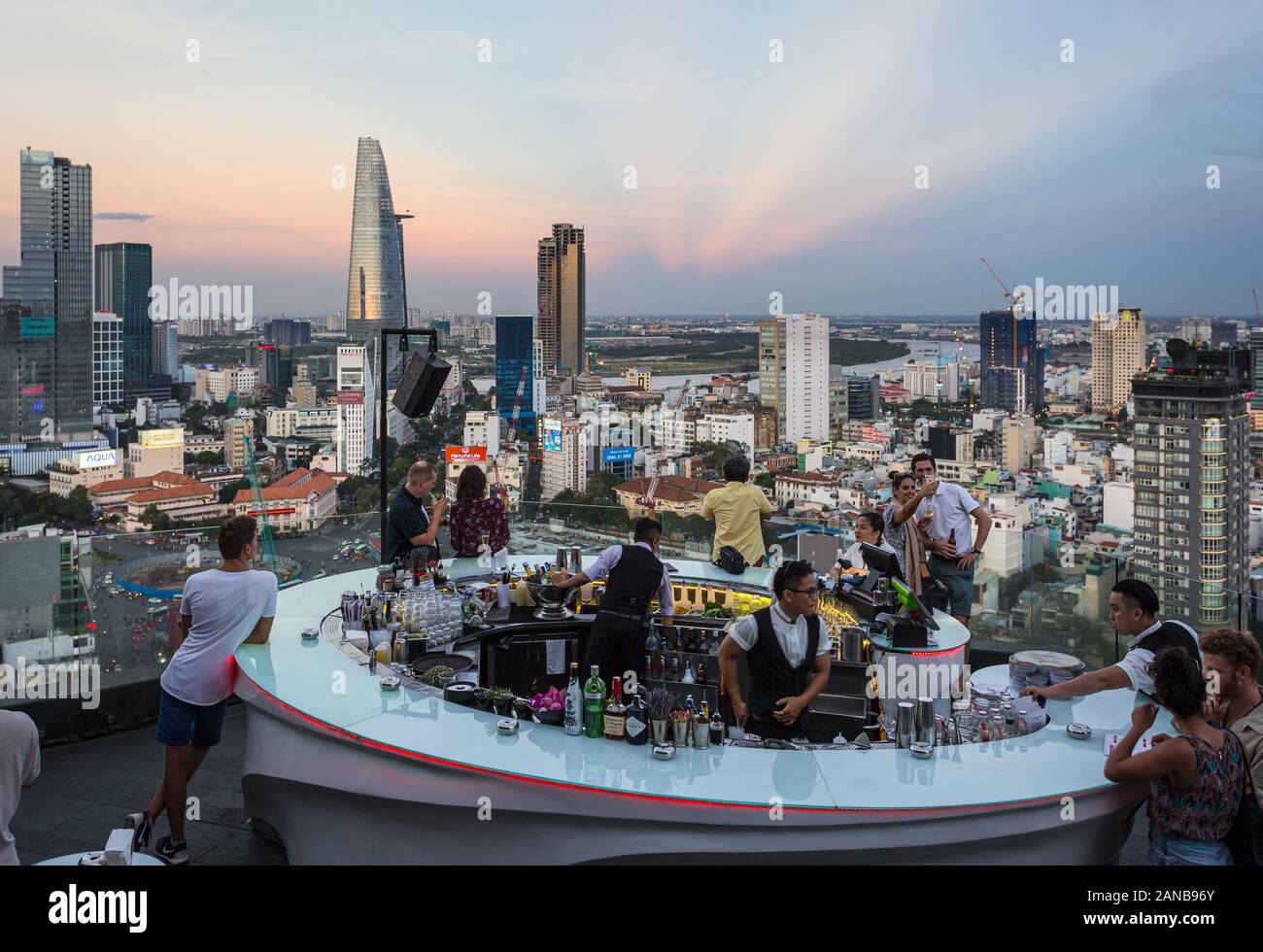 La città di Ho Chi Minh, Vietnam - 17 Marzo 2018: il turista a godere di un drink in un bar sul tetto sopra la skyline di Saigon durante il tramonto in Vietnam la più grande città in modo Foto Stock