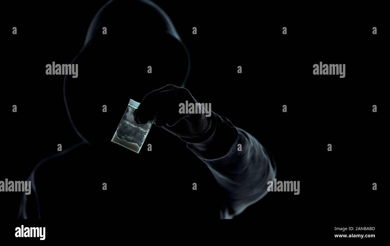 Close-up di uomo sconosciuto che mostra il pacchetto con eroina in telecamera, il trafficante di droga Foto Stock