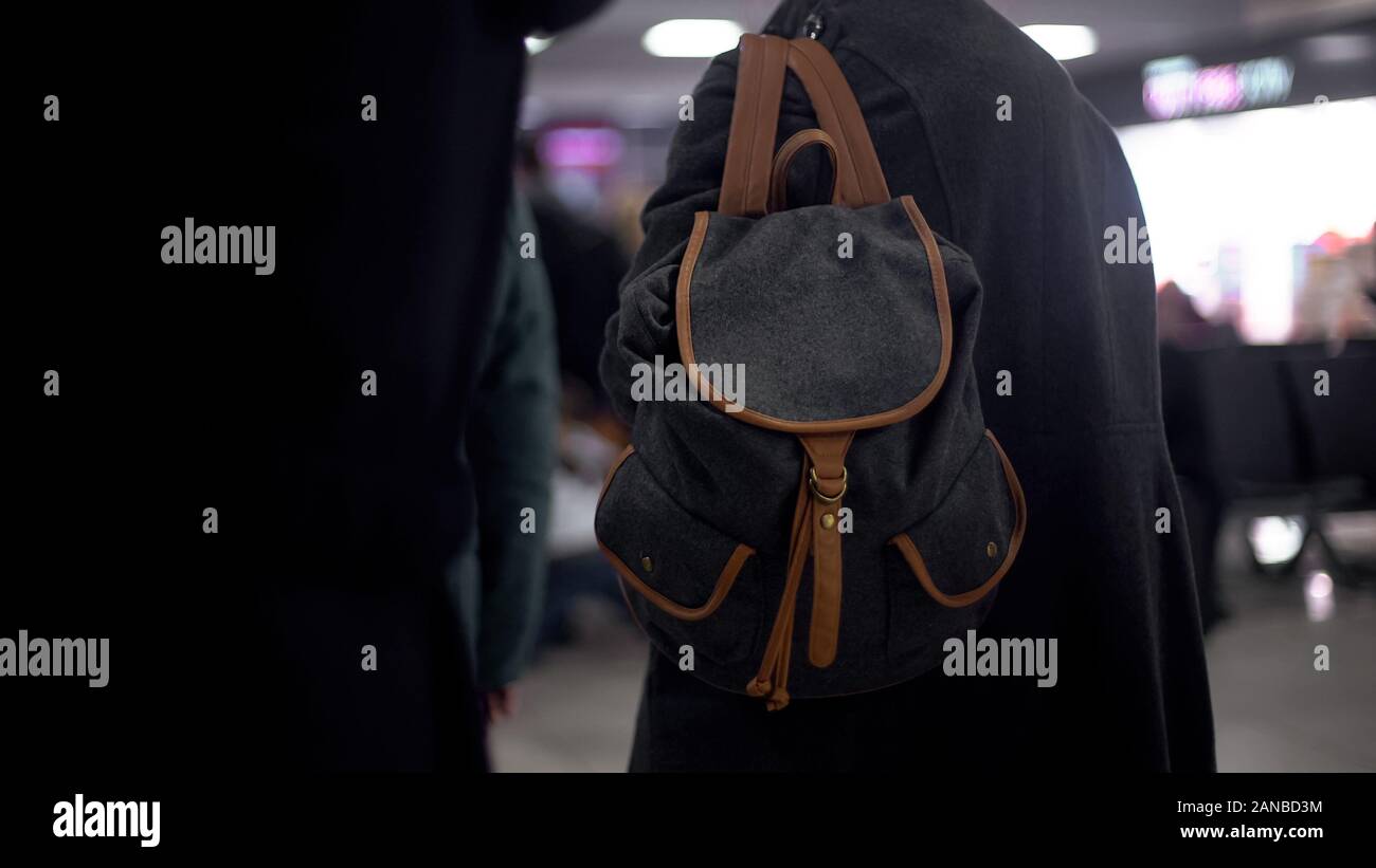 Vista posteriore del turista con zaino in attesa treno, rischio di borseggio, criminalità Foto Stock