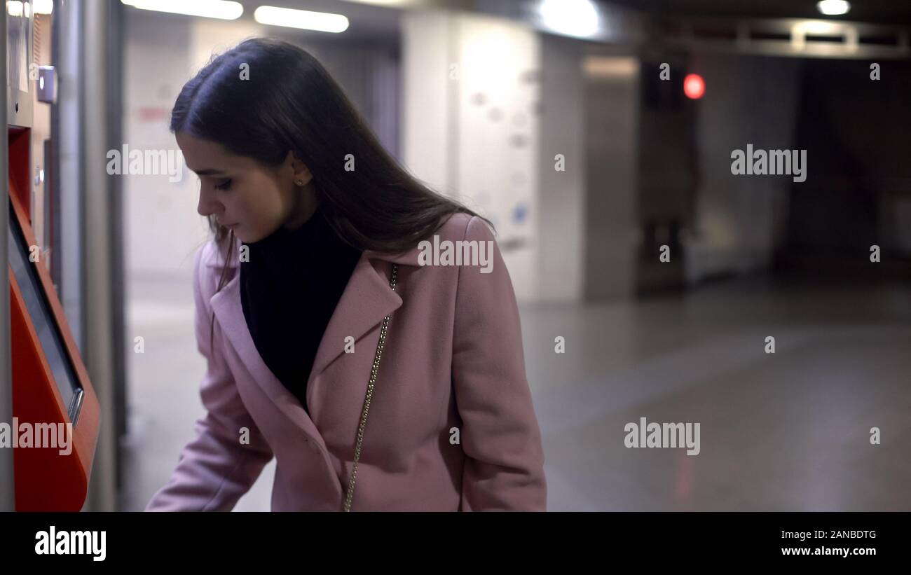 Donna benestante prelevare denaro in ATM di notte, finanza, rischio criminalità Foto Stock