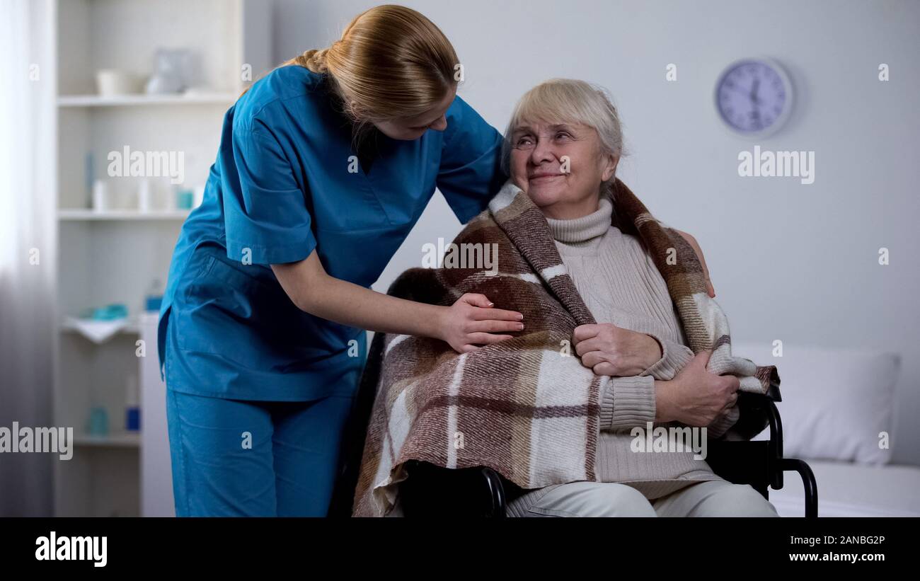 Tipo di copertura infermiere con coperta handicappati vecchia donna, ospedaliera, service Foto Stock