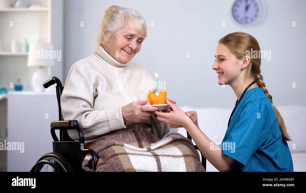 Medico donna dando la torta di compleanno per handicappati donna, nursing home care Foto Stock