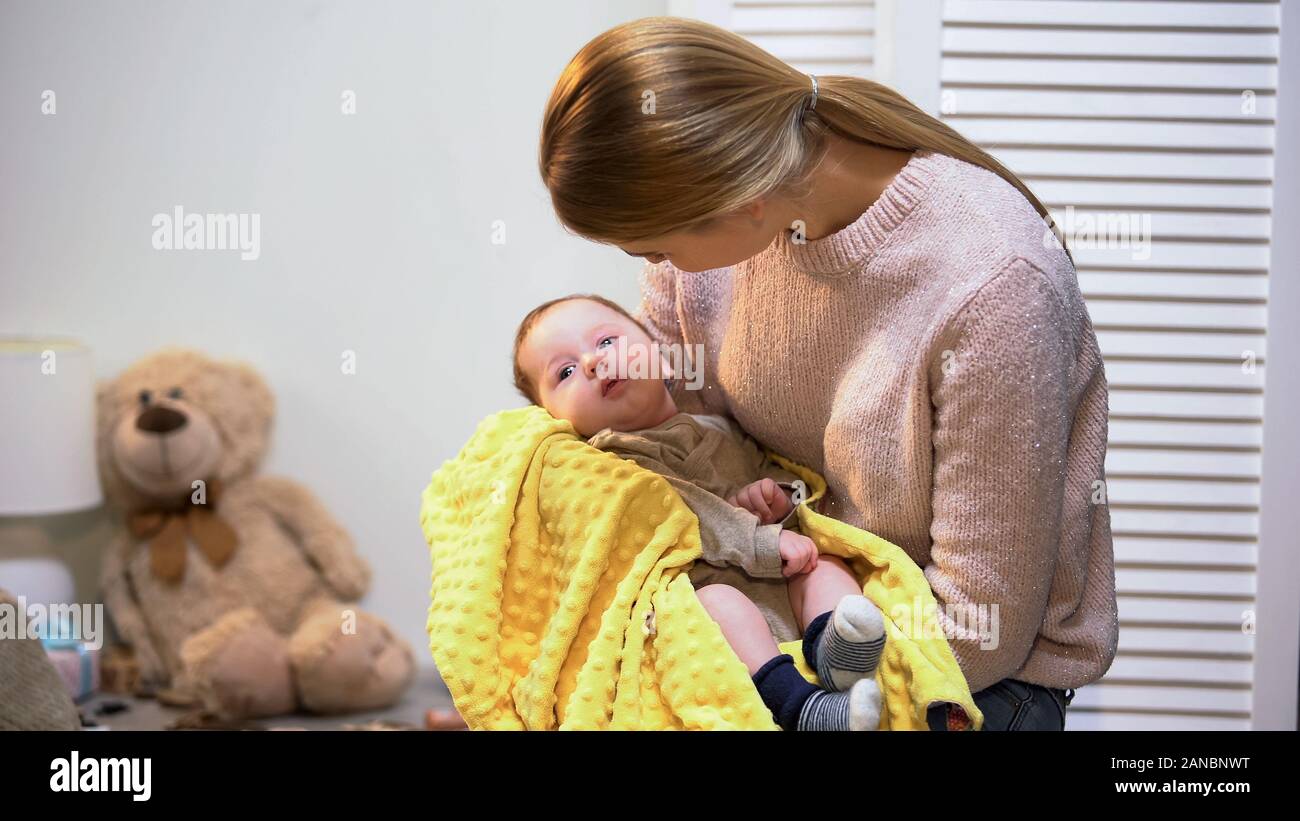 Giovane e bella madre holding bimbo piccolo figlio di armi, neonato amore e cura Foto Stock