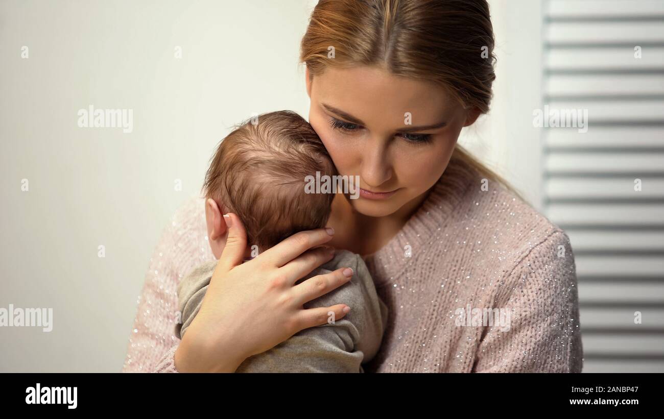 Gara mommy cuddling adorabili poco baby, tenendo il neonato in armi, amore Foto Stock