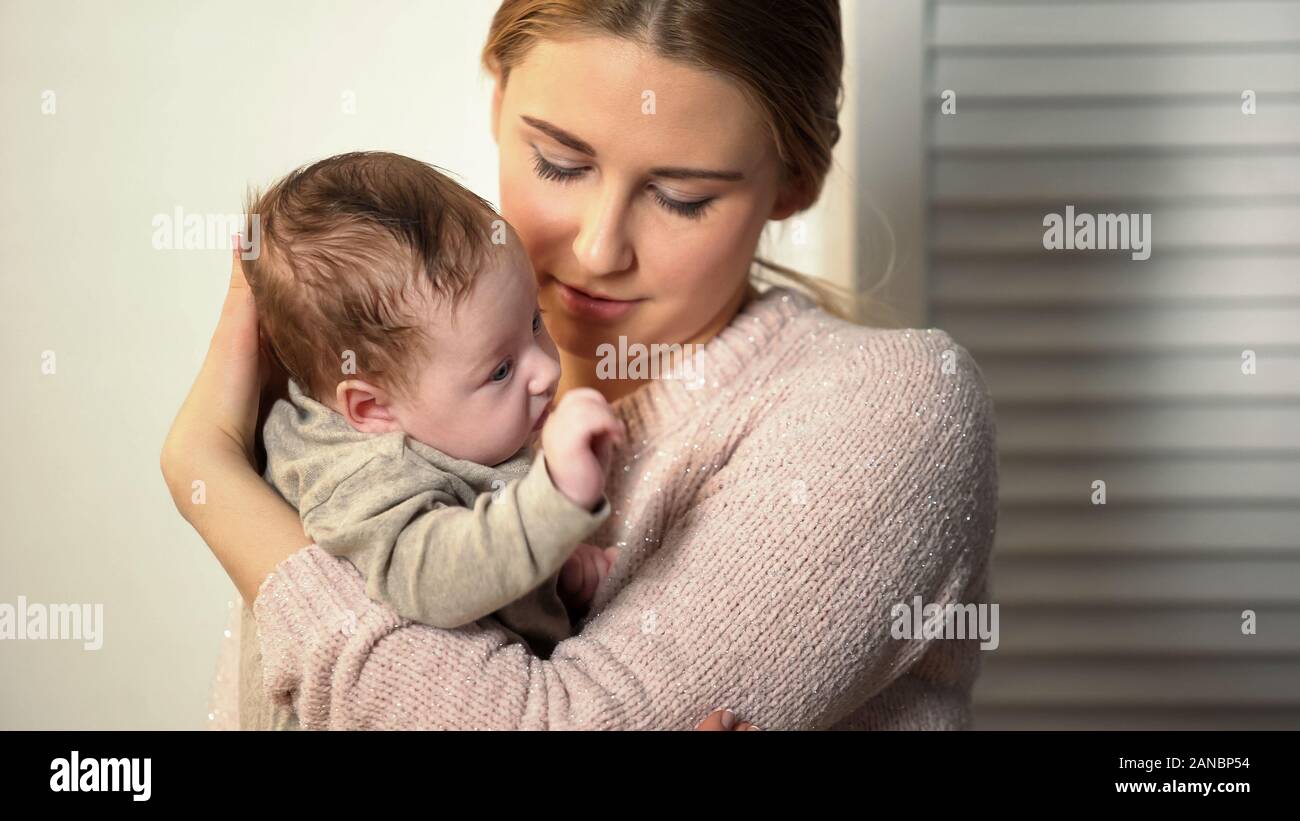 Babysitter tenendo poco adorabile neonato in orfanotrofio, adozione nella nuova famiglia Foto Stock