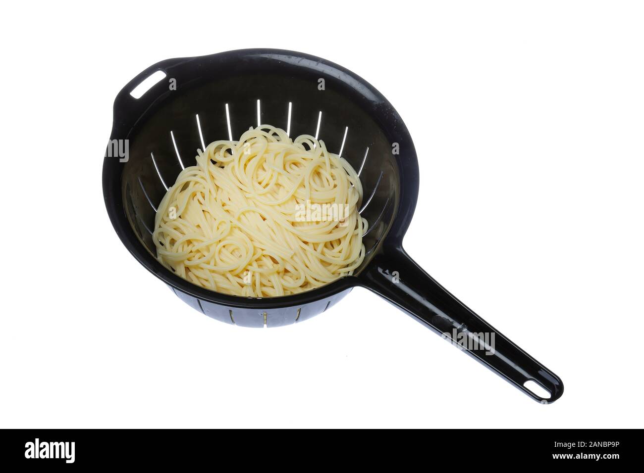 Vista dall'alto di un nero colapasta di plastica riempiti con spaghetti isolati su sfondo bianco. Foto Stock