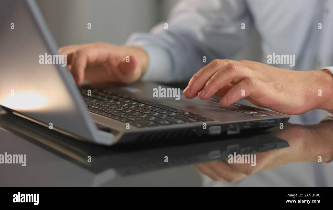 Mani maschio digitando su laptop, azienda dipendente che lavora in ufficio, la ricerca di informazioni Foto Stock