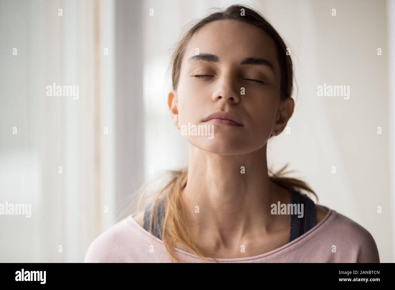 Calma giovane donna seduta con gli occhi chiusi. Foto Stock