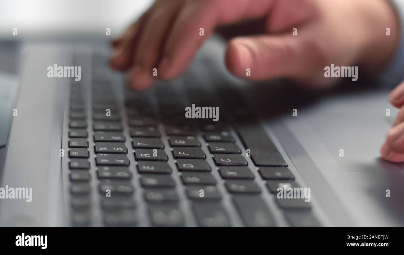 Dita maschio premendo i pulsanti sulla tastiera portatile closeup, il lavoro di ufficio, dispositivo Foto Stock