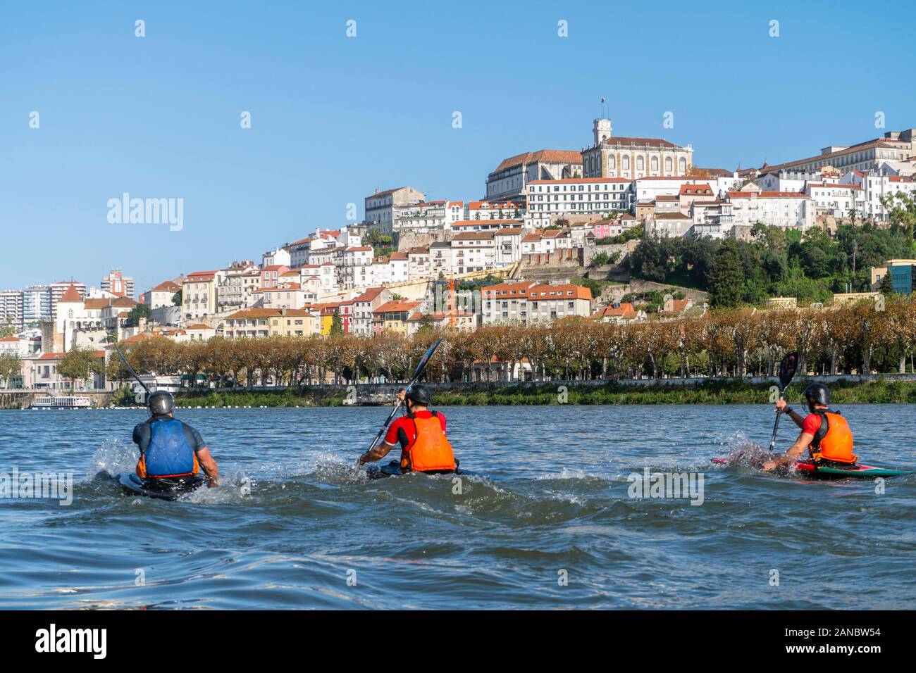 Tre uomini in canoe esercita sul fiume Mondego in Coimbra, Portogallo Foto Stock