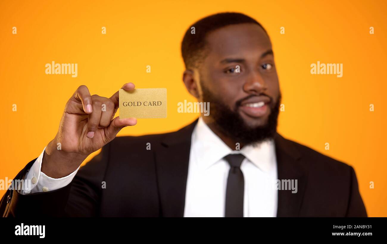 Moda afro-americano in abito formale che mostra la carta oro, club membership Foto Stock