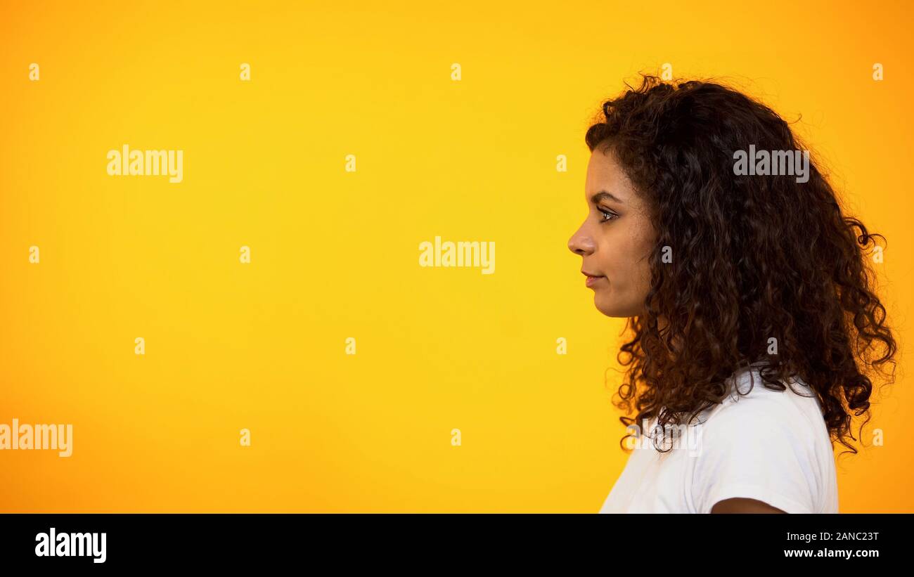 Vista laterale della bella donna afro-americana isolato su sfondo giallo Foto Stock