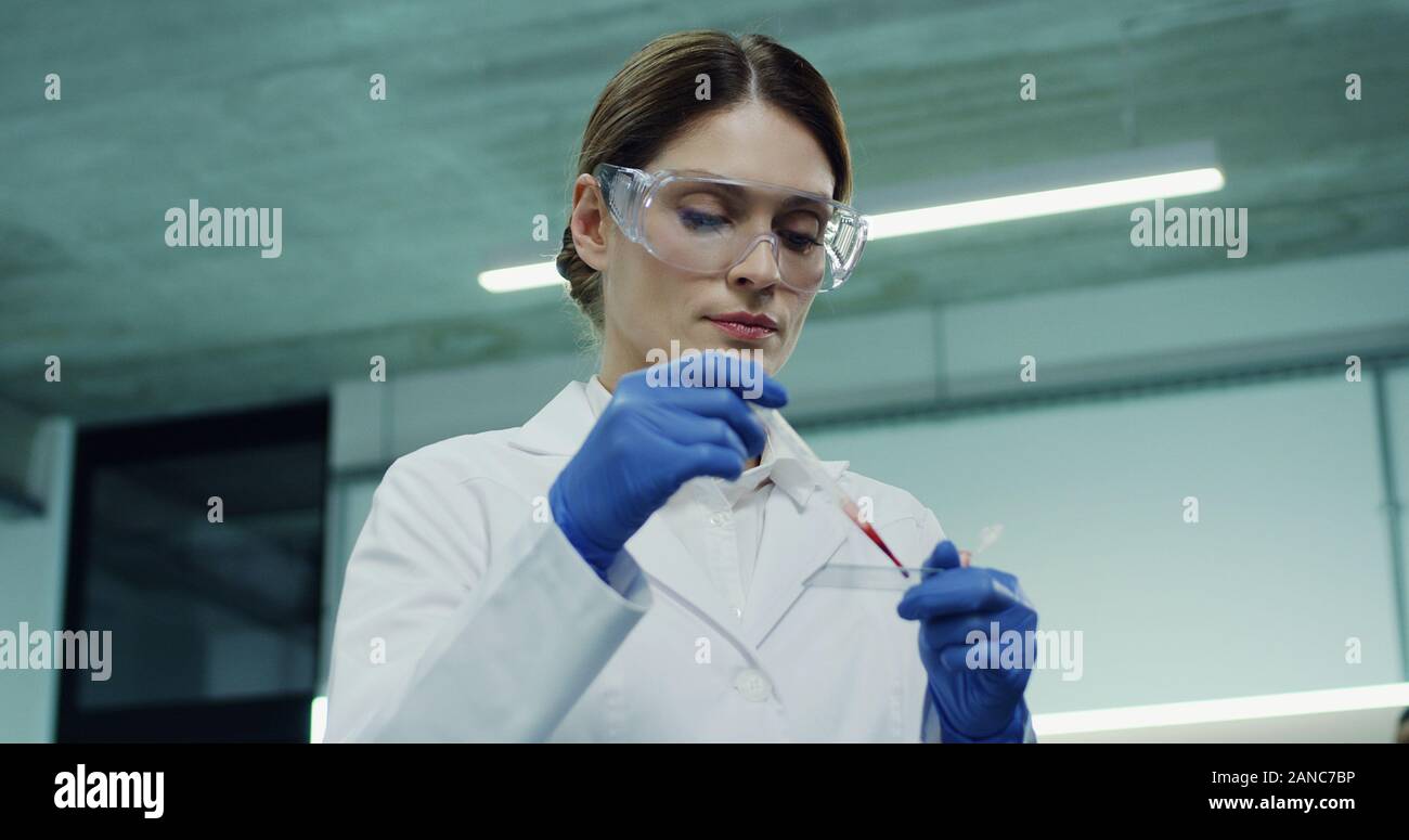 Ritratto di Pastore del Caucaso bellissima femmina lavoratore laboratorio di effettuare un esame del sangue nel tubo di vetro a mani. Close up. Foto Stock